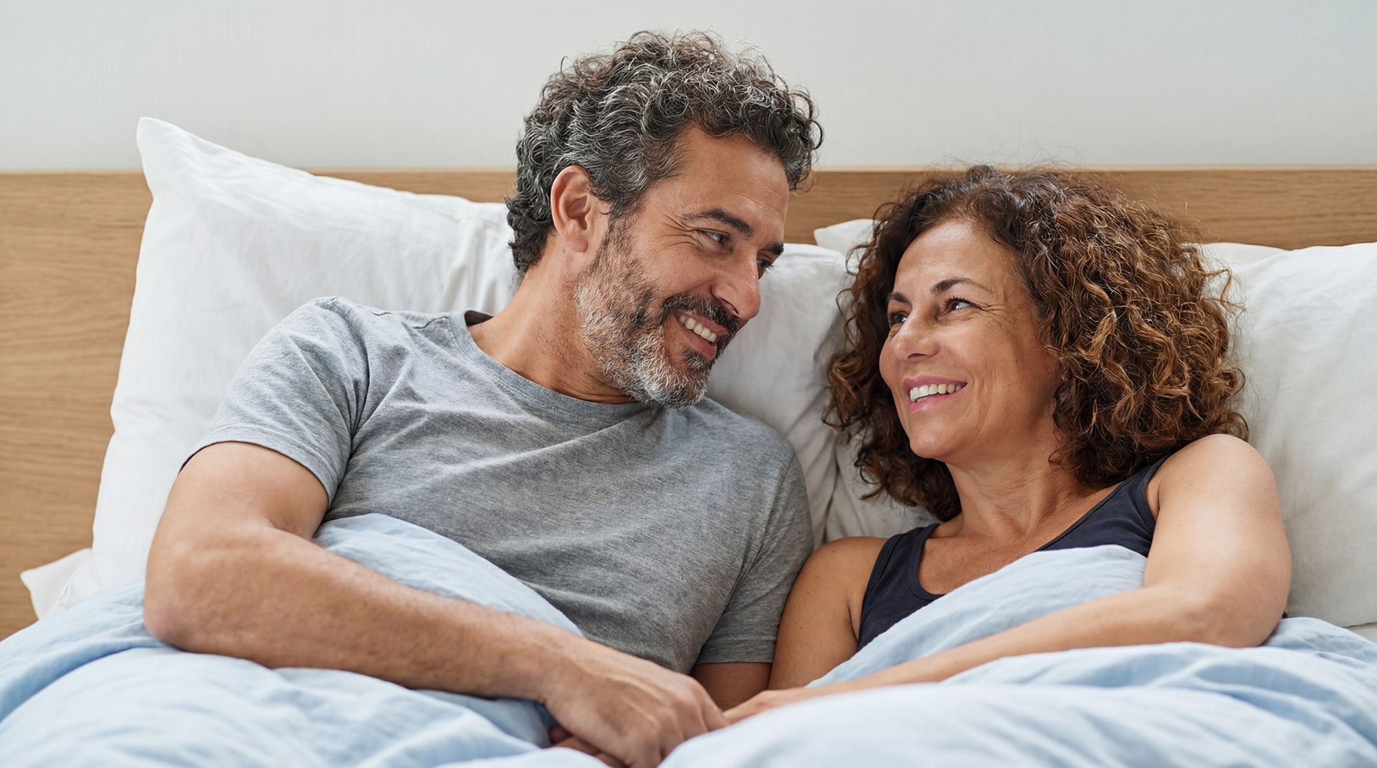 Person waking up happy and well-rested in a comfortable Instant Comfort luxury bed