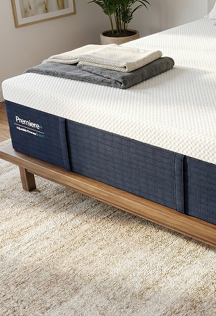Bed with Premier's mattress topper on a wooden bed frame in a room setting.