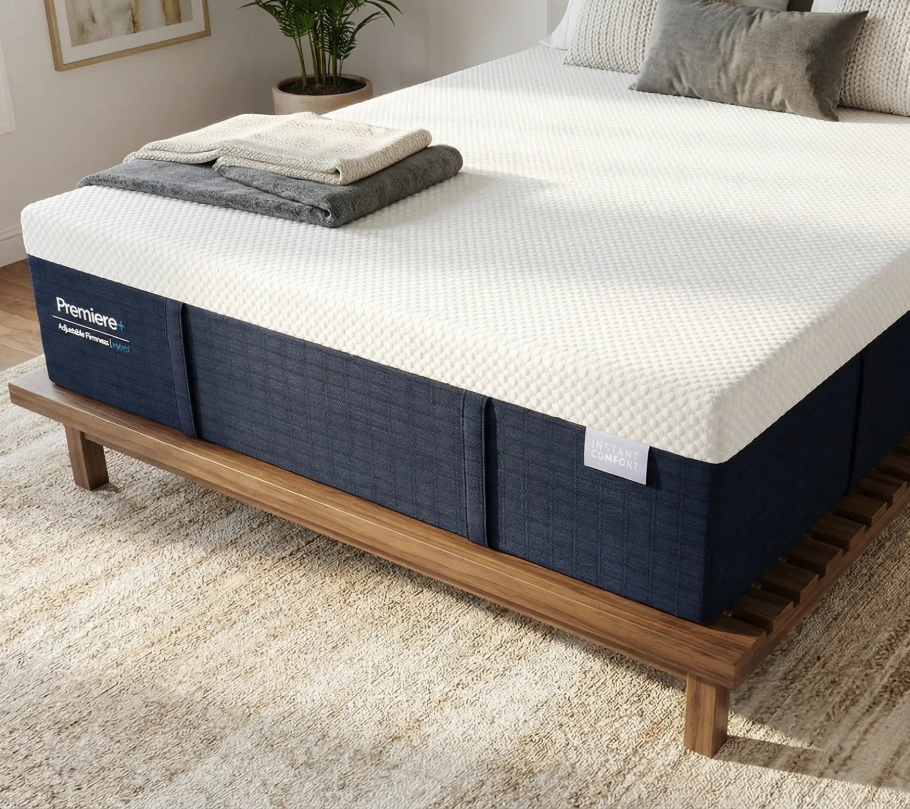 Blue mattress on a wooden bed frame with white bedding in a room setting.